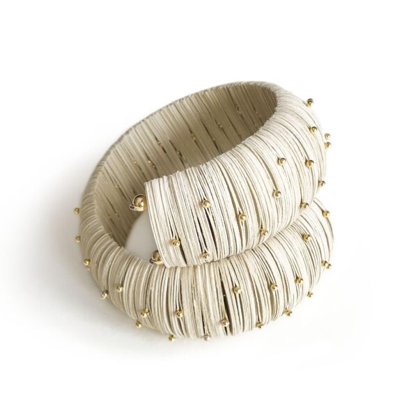 Ivory-white bracelet with small golden pins