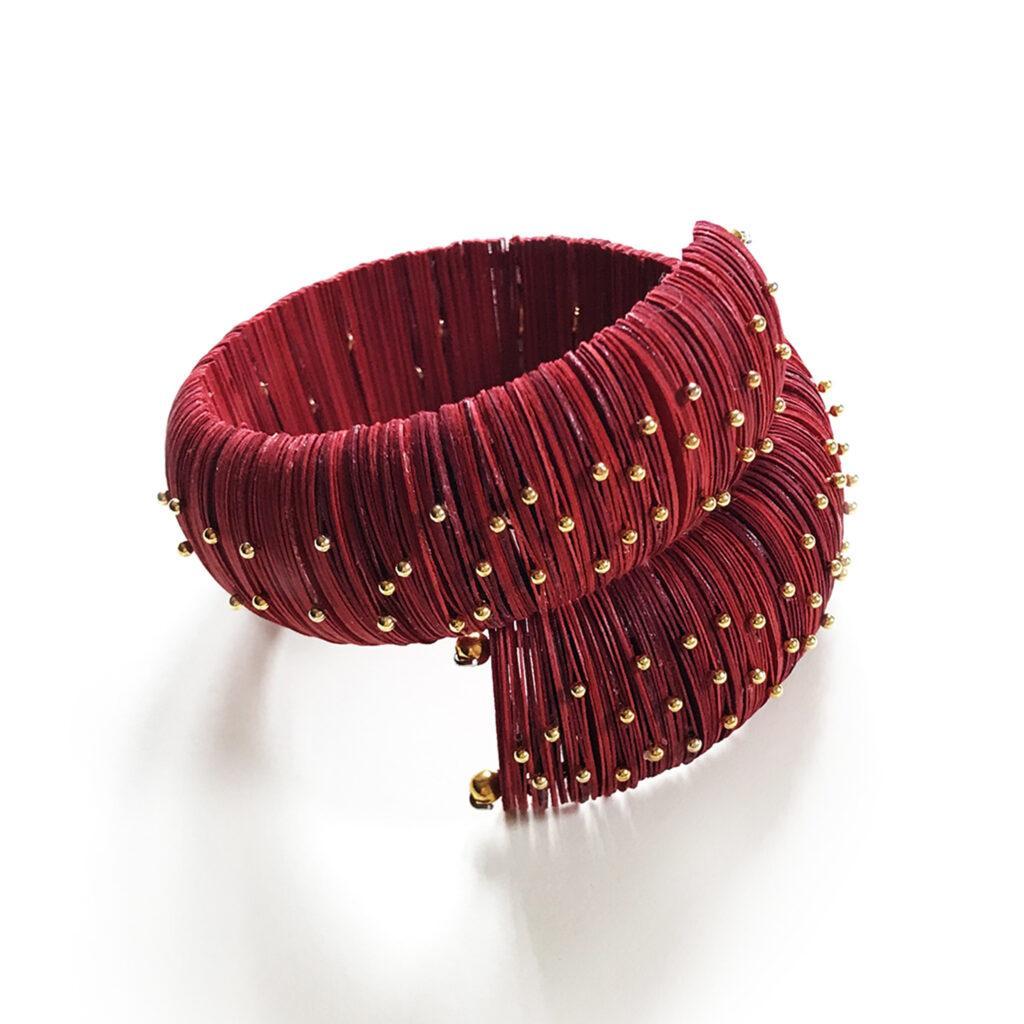Bracciale rosso con perni dorati